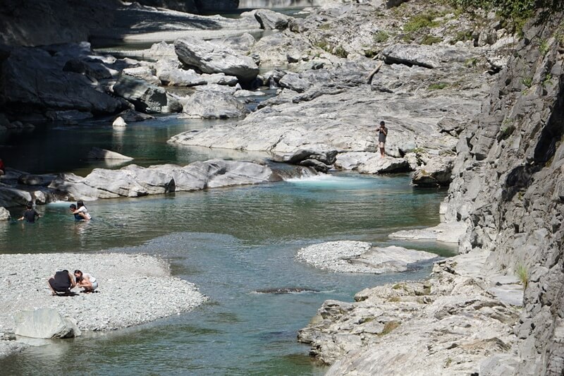 There are many people playing in the water at Iya Valley